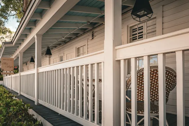 White porch railings and columns beneath a pale blue painted ceiling